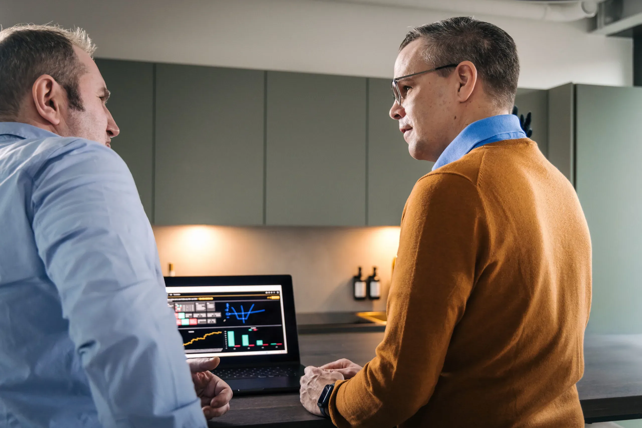 Berater und Kunde analysieren gemeinsam Kursdaten am Laptop